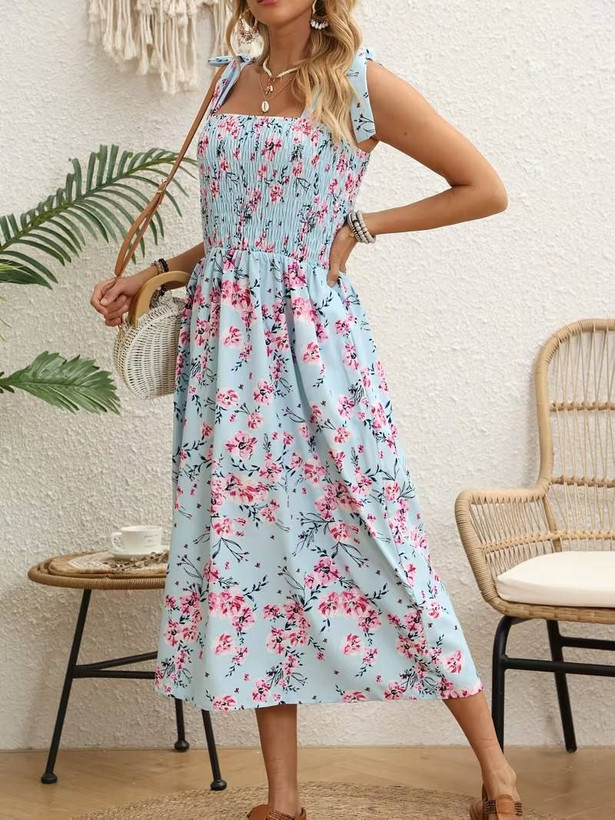 پیراهن آبی آسمانی طرح شکوفه صورتی با سینهکش و بندهای گرهدار، مناسب استایل تابستانی و مهمانی، قد ۱۱۵ تا ۱۲۵ سانتیمتر، سایز ۳۸ تا ۴۸.